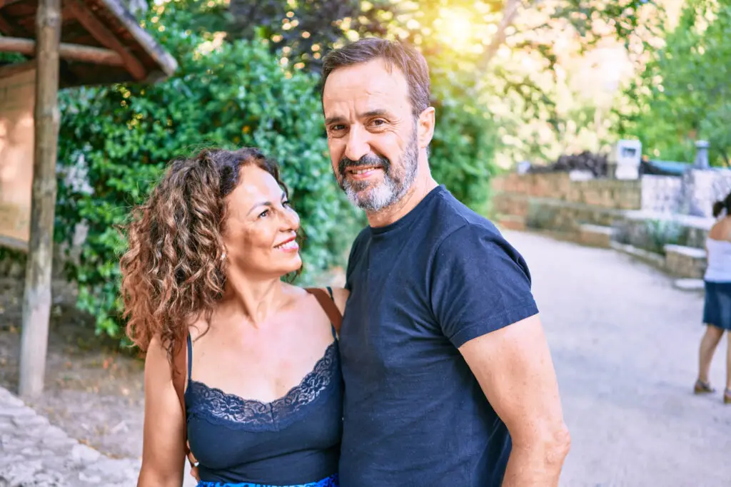 Middle age couple wearing casual clothes smiling happy at the forest