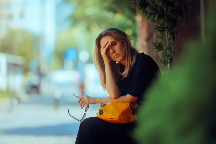 Stressed Woman Suffering a Headache Resting Outdoors